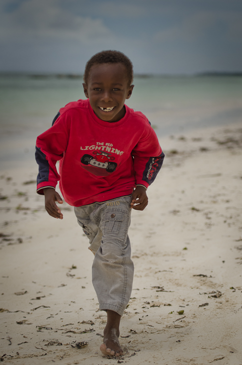  Chłopiec Jambiani Ludzie Nikon D7000 AF-S Nikkor 70-200mm f/2.8G Zanzibar 0 plaża czerwony zbiornik wodny osoba piasek woda dziecko wakacje zabawa na stojąco
